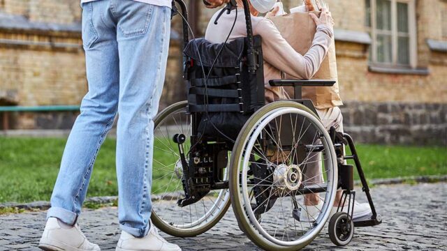 man-pushing-an-eldery-woman-in-a-wheelchair