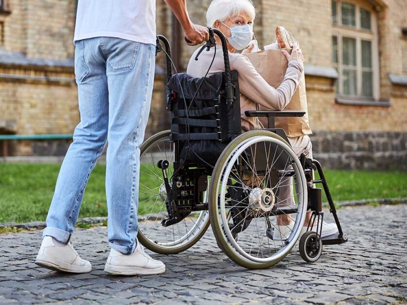 man-pushing-an-eldery-woman-in-a-wheelchair