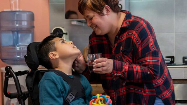 woman-feeding-a-disabled-boy-on-a-wheel-chair