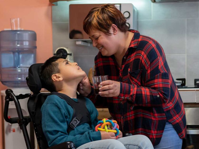 woman-feeding-a-disabled-boy-on-a-wheel-chair